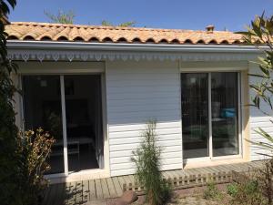 eine abgeschirmte Veranda eines Hauses mit Glasschiebetüren in der Unterkunft Cabane Blanche in Andernos-les-Bains