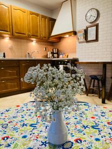 eine Vase mit weißen Blumen auf dem Tisch in der Küche in der Unterkunft Apartament Gęsie Piórko in Jastrzębia Góra