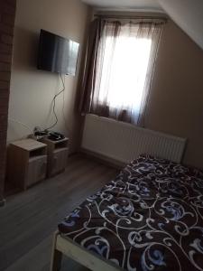 een slaapkamer met een bed en een raam bij Nefelejcs Nyaraló-Vendégház in Dunasziget