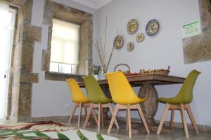 een eetkamer met een tafel met gele en groene stoelen bij Casa Moiano in Oliveira do Hospital