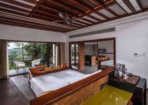 a bedroom with a bed and a living room at Great Trails Wayanad by GRT Hotels in Wayanad