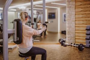 a woman is exercising in a gym at Hotel Berghof - St Johann in Salzburg in Sankt Johann im Pongau