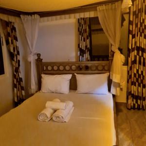 una camera da letto con un letto e due asciugamani di Karibuni palace mtwapa a Mtwapa