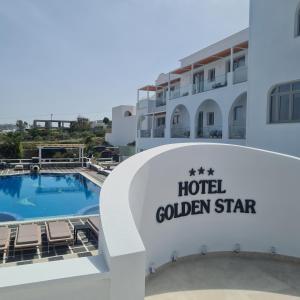 un cartello per una stella d'oro dell'hotel con piscina di Golden Star a Firà