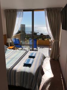 a bedroom with a bed and a view of the ocean at Departamento Algarrobo in Algarrobo