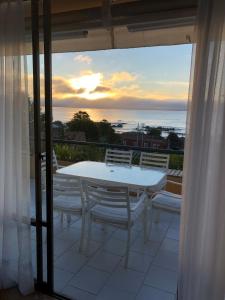 a table and chairs on a balcony with a view of the ocean at Departamento Algarrobo in Algarrobo