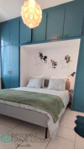 a bedroom with a large bed with blue cabinets at Résidence Sainte Cécile in Thionville