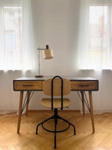 a desk with a lamp and a chair in a room at Der Stadtzirkus in Klagenfurt