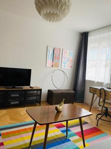 a living room with a coffee table and a tv at Der Stadtzirkus in Klagenfurt