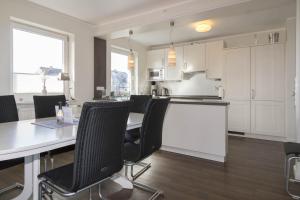 a kitchen and dining room with a table and chairs at Hüs Auert Tharep, Wohnung 5 in Hörnum