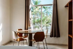 una sala da pranzo con tavolo, sedie e finestra di Loft Hotel Malecón Vallarta a Puerto Vallarta