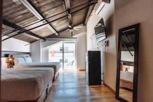 una stanza con due letti e uno specchio di Loft Hotel Malecón Vallarta a Puerto Vallarta