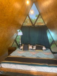 a bed in a tree house with a window at Chalets Resort Masinagudi in Ooty