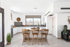 cocina blanca con mesa y sillas en Perfect Villa, en Beer Sheva