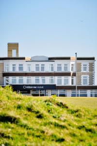 een groot gebouw voor een groen veld bij The Kilbirnie Hotel in Newquay