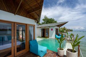 uma casa sobre a água com uma piscina em Indigo Blue Ceningan em Nusa Lembongan