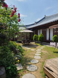 een tuin voor een gebouw met een tafel bij Sori poonggyung in Jeonju