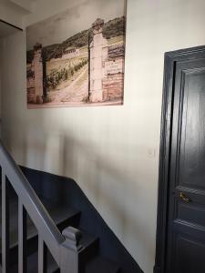 a painting hanging on a wall next to a staircase at Clos Terre-lune in Nuits-Saint-Georges