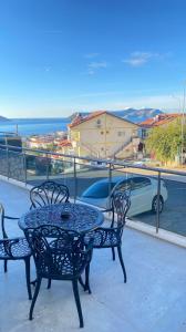 einen Tisch und Stühle auf einem Balkon mit Auto in der Unterkunft Happy Kaş Apart in Kaş