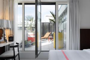 a bedroom with a bed and a sliding glass door at Ruby Claire Hotel Geneva in Geneva