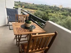 een houten tafel en 2 stoelen op een balkon bij Rosamar in Alvor