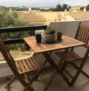 een houten tafel en 2 stoelen op een balkon bij Rosamar in Alvor