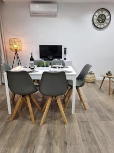 een eetkamer met een witte tafel en stoelen bij Rosamar in Alvor