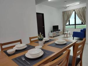 Cozy Condo at Melaka Top Hill, 7-9pax في آير كيروه: غرفة طعام مع طاولة مع أطباق وكراسي