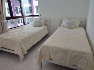 Cozy Condo at Melaka Top Hill, 7-9pax في آير كيروه: غرفة نوم بسريرين ونافذة