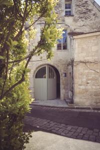 un edificio con una gran puerta y un edificio de piedra en Maison Paul & Gabrielle, en Chablis