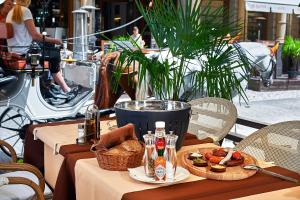 einen Tisch mit einem Teller Essen und einem Korb Brot in der Unterkunft Salvator Hotel in Karlsbad