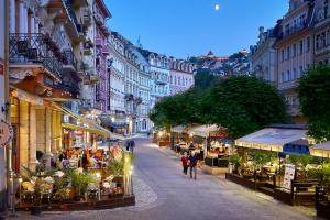 Eine Stadtstraße mit Leuten, die eine Straße entlang laufen in der Unterkunft Salvator Hotel in Karlsbad