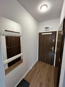 um quarto vazio com uma porta e um piso de madeira em Apartament Love Góry Karpacz Centrum em Karpacz