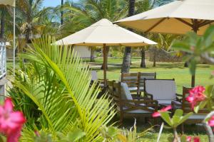 een groep stoelen en tafels met parasols bij Ocean Beach Resort & SPA in Malindi