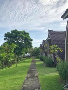 una entrada que conduce a una casa con un patio de césped en The Ulus Klumpu, en Uluwatu