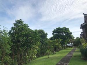 un parque con árboles y un edificio al fondo en The Ulus Klumpu, en Uluwatu