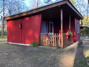 a red building with a fence in front of it at Gast-& Logierhaus Am Rheinsberger See in Rheinsberg