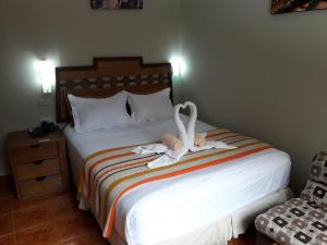 Un dormitorio con una cama con dos cisnes. en Hostal Vista Waynapata 123, en Machu Picchu