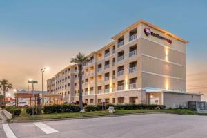 een hotel met een parkeerplaats ervoor bij Best Western Plus Galveston Suites in Galveston