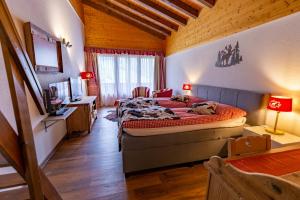 Schlafzimmer mit einem Bett, einem Schreibtisch und einem TV in der Unterkunft Chalet-Hotel Beau-Site in Adelboden