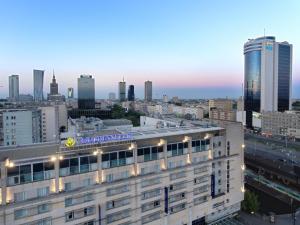 um edifício com um sinal em cima dele numa cidade em Golden Tulip Warszawa Centrum em Varósvia