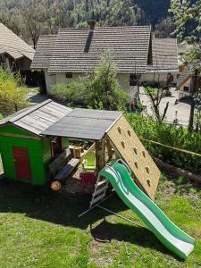 een speeltuin met een glijbaan en een speelhuis bij Turistična kmetija Pri Andreju in Bohinj