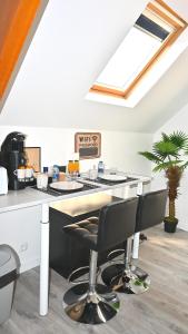 a kitchen with a counter and chairs in a room at COSY CHAMBRE CHEZ HABITANT 5mn Aéroport Roissy CDG in Le Mesnil-Amelot