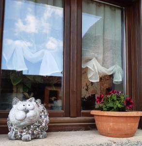 a statue of a cat sitting in front of a window at C'era una volta in Castelnuovo Don Bosco