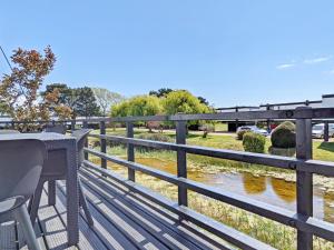 une terrasse en bois avec un banc et une rivière dans l'établissement 6 Avocet Quay, Emsworth, à Emsworth