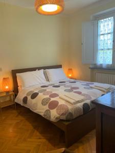 een slaapkamer met een groot bed met 2 lampen erop bij Villa Favilli in Pisa