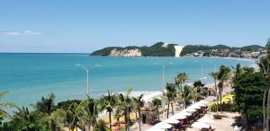 vista su una spiaggia con palme e sull'oceano di Araça Flat Natal Prime - Beira Mar a Natal