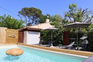 - une piscine avec des chaises et des parasols à côté d'une maison dans l'établissement la souquette, à Draguignan