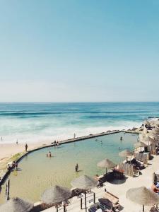 un grupo de personas nadando en una piscina en la playa en Azenhas do Mar Roadside House, en Colares