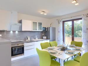 une cuisine avec une table à manger et des chaises vertes dans l'établissement Apartment Joy by Interhome, à Pula